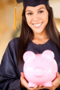 Young woman in graduation cap and gown holding a piggy bank.